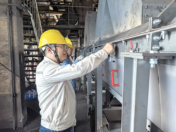 071751879018107137.jpg 技術員林佳峰、副班長朱新站查看全封閉導料槽完工情況.jpg